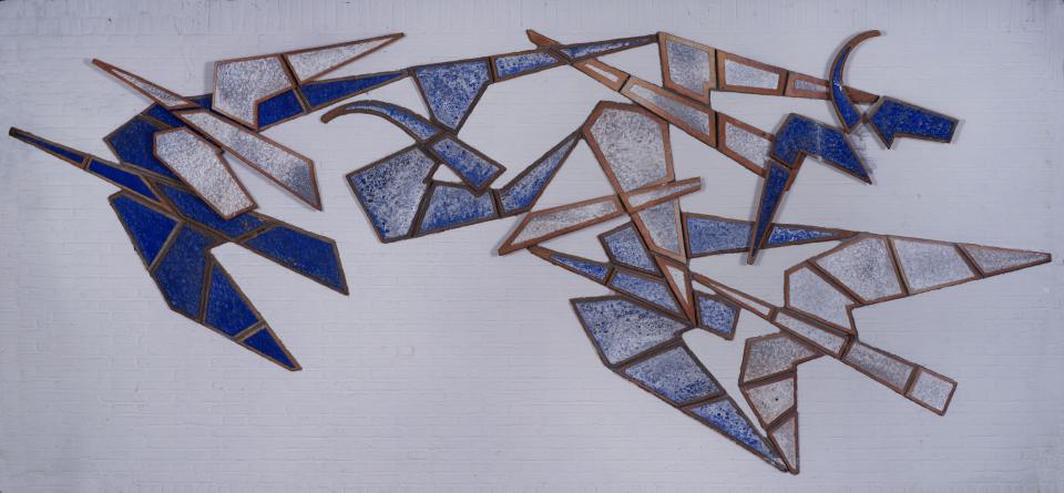 Een foto van een wand-kunstwerk met keramiek