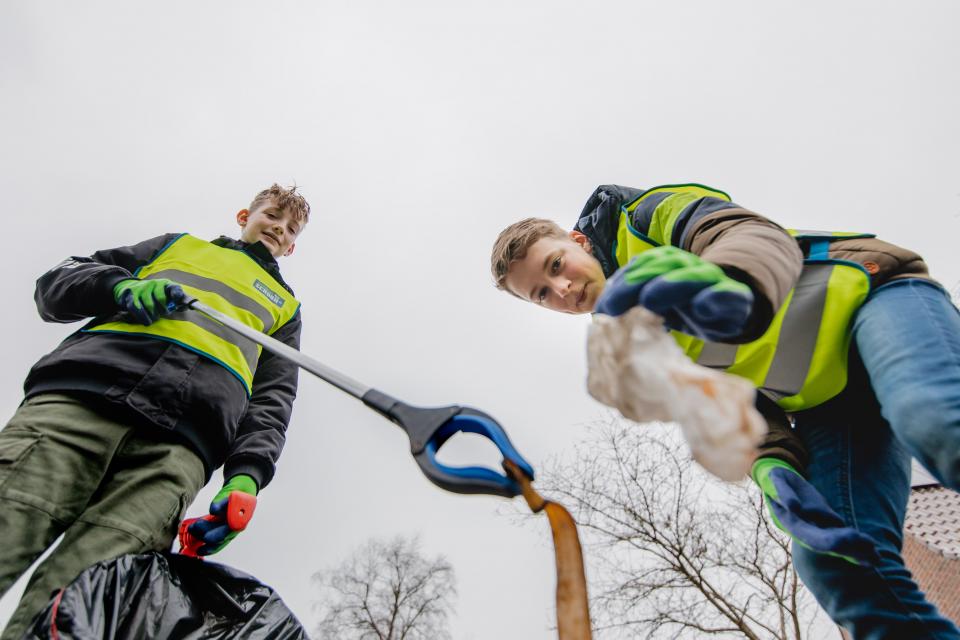 Twee jongens rapen zwerfafval op