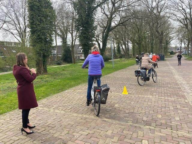Wethouder Peters kijkt toe bij fietsers die meedoen aan fietsactiviteit Doortrappen