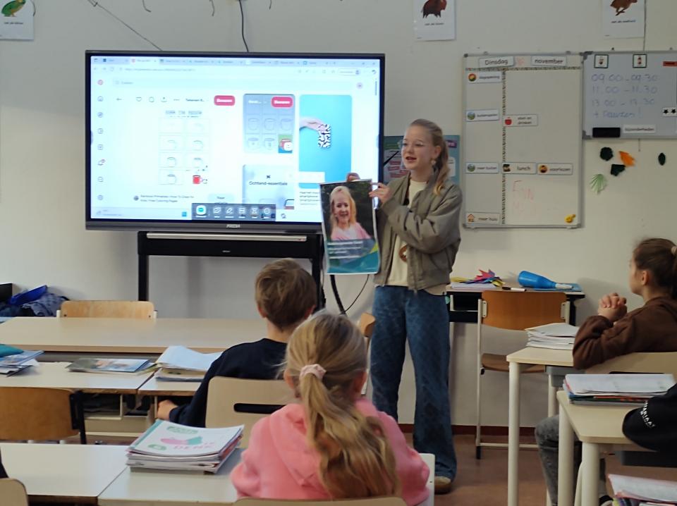 Kinderburgemeester Sarah staat voor een klas en vertelt wat ze allemaal doet