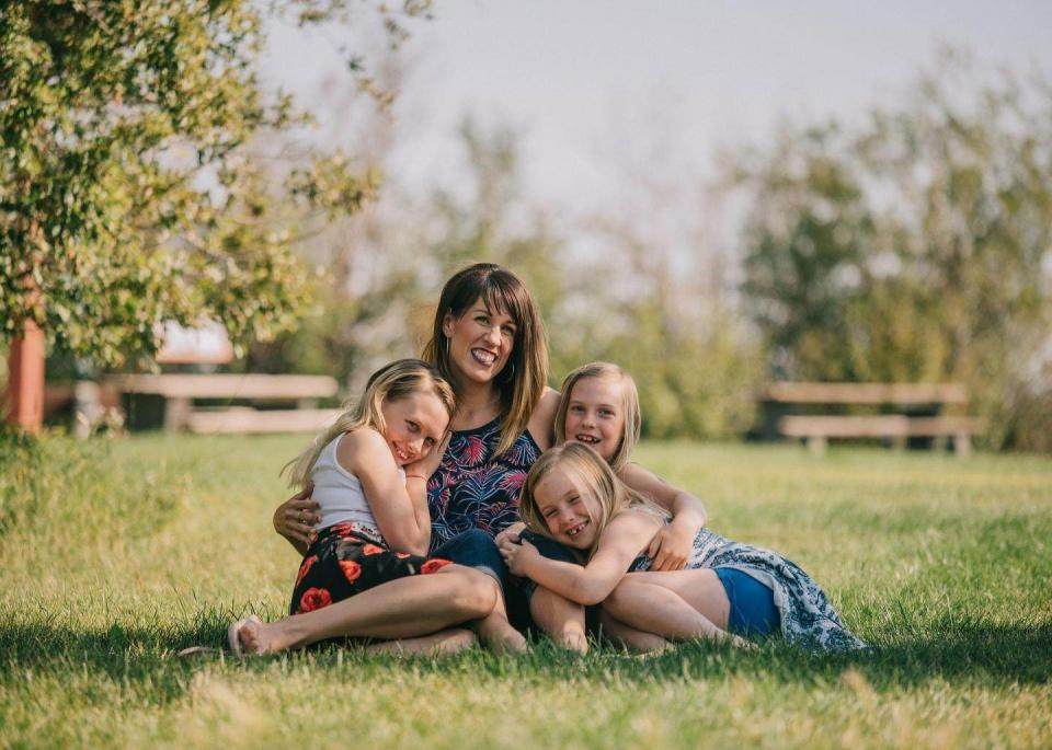 Jonge moeder, met drie kinderen in het gras aan het chillen