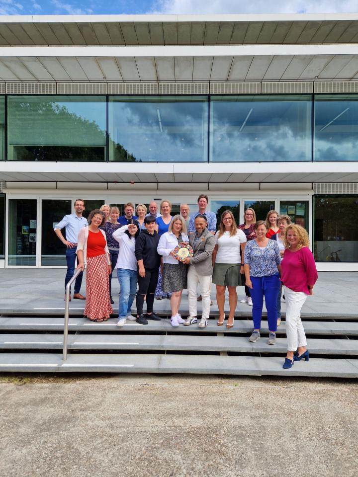 Een groep Oekraieners die samen met de wethouders het herinneringsbord laten zien 